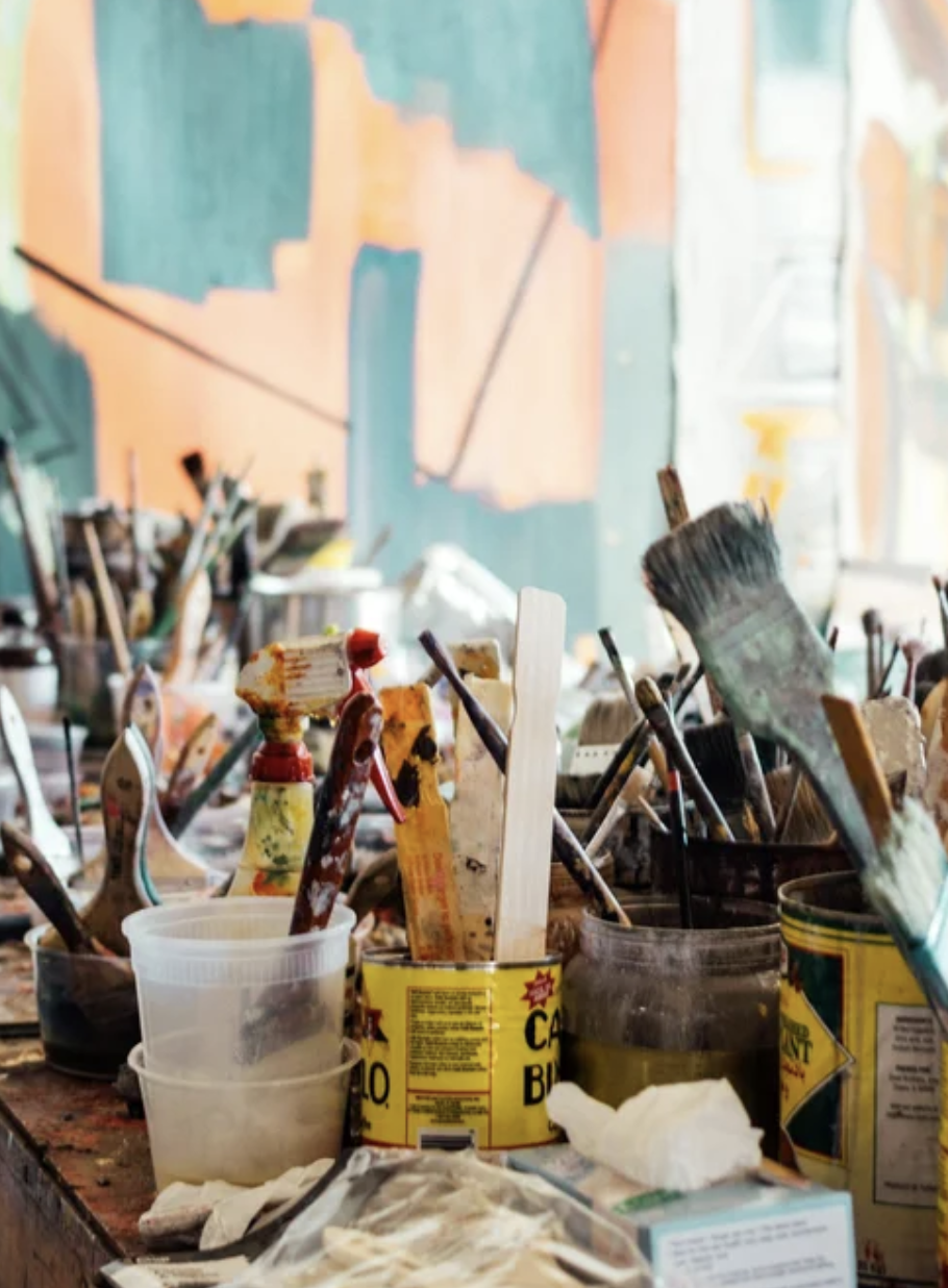 Brushes, tools and paint tins on a working studio table